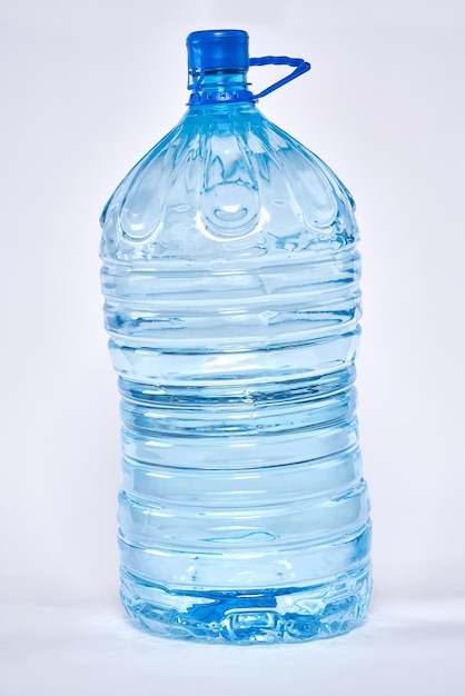 Blauwe doorzichtige plastic fles water geïsoleerd op een witte achtergrond.