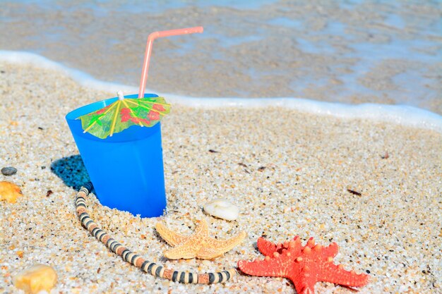 Blauwe drank met schelpen en ketting aan de kust