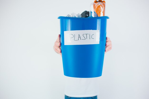 Blauwe emmer met plastic. Klaar voor recycling en milieuproces. Zorg voor ecologie.