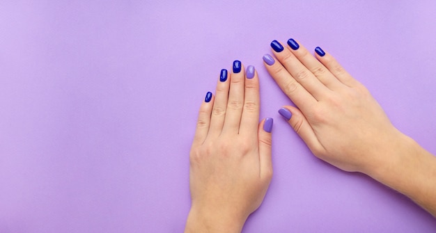 Blauwe en lila manicure op handen van de vrouw