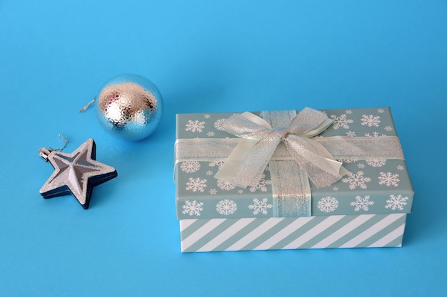 blauwe en witte geschenkdoos met zilveren kerstspeelgoed geïsoleerd, close-up
