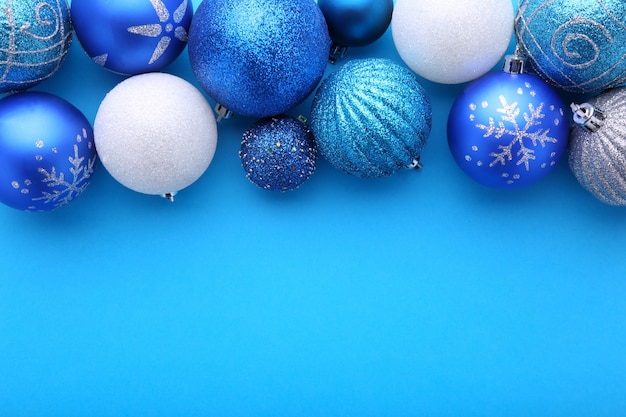 Blauwe en zilveren kerstballen op een blauwe achtergrond