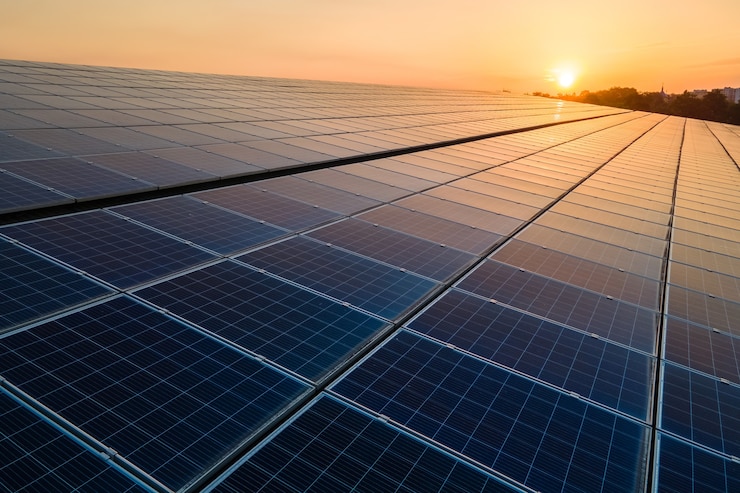 Foto blauwe fotovoltaïsche zonnepanelen gemonteerd op het dak van een gebouw voor het produceren van schone ecologische elektriciteit bij zonsondergang. productie van hernieuwbare energieconcept.