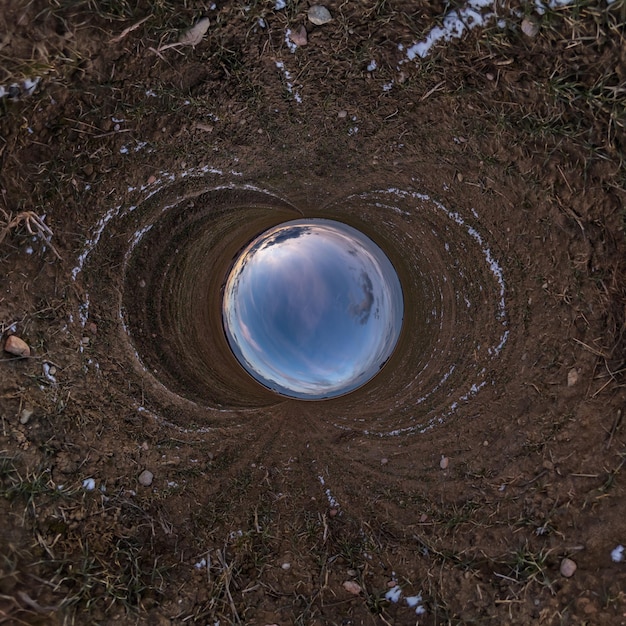 Blauwe gat bol kleine planeet in zand of droog gras ronde frame achtergrond