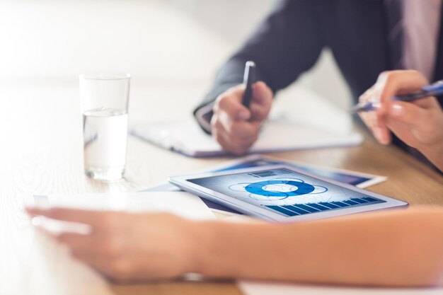 Foto blauwe gegevens tegen zakenmensen die tablet gebruiken