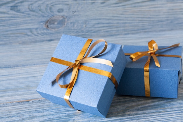 Blauwe geschenkdozen met gouden linten op een blauwe houten voor Kerstmis, Nieuwjaar, verjaardag of Valentijnsdag