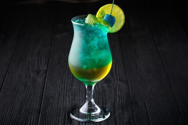 Blauwe Hawaiiaanse cocktail met munt op zwarte achtergrond