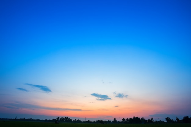 Blauwe hemel achtergrondtextuur met witte wolkenzonsondergang.