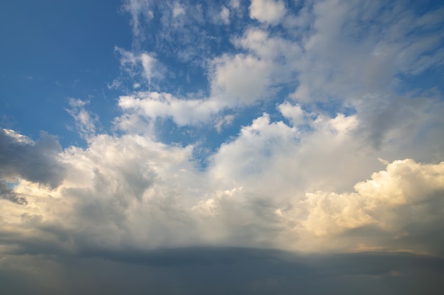 Blauwe hemel bedekt met witte gezwollen wolken.