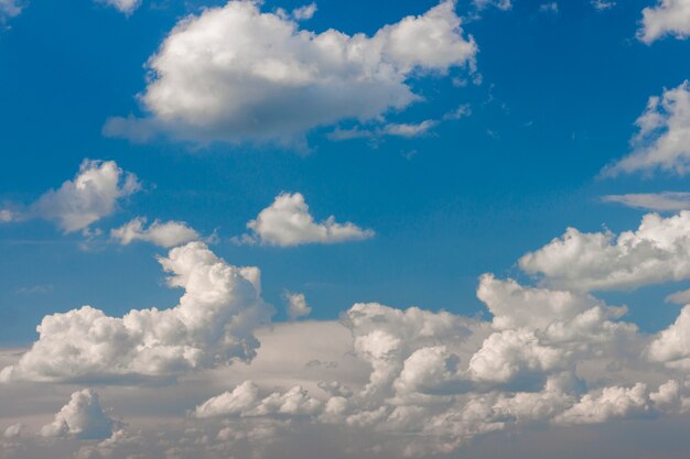 Blauwe hemel met gezwollen witte wolken in heldere heldere zonnige dag