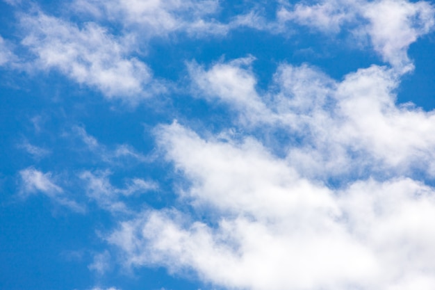 Blauwe hemelachtergrond met kleine wolken