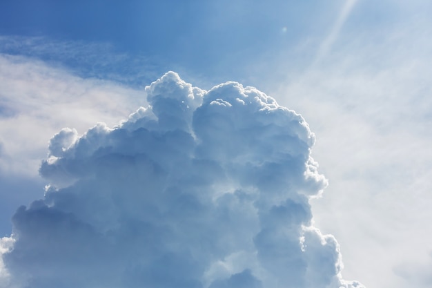 Blauwe hemelachtergrond met kleine wolken.