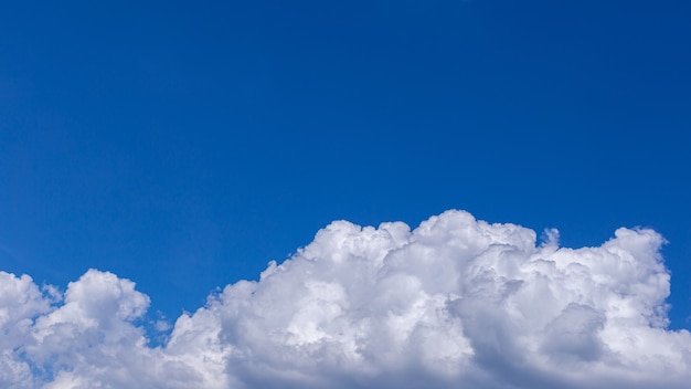 Blauwe hemelachtergrond met kleine wolken