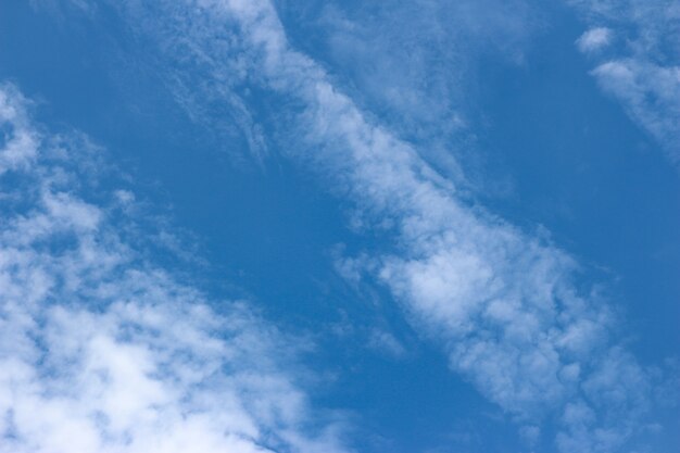 Blauwe hemelachtergrond met kleine wolken