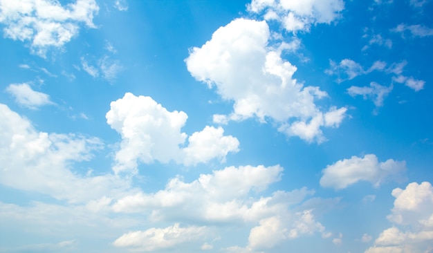 Blauwe hemelachtergrond met kleine wolken