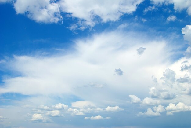 Blauwe hemelachtergrond met kleine wolken