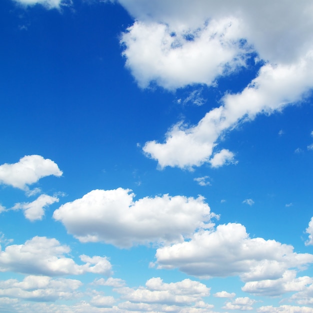 Blauwe hemelachtergrond met kleine wolken