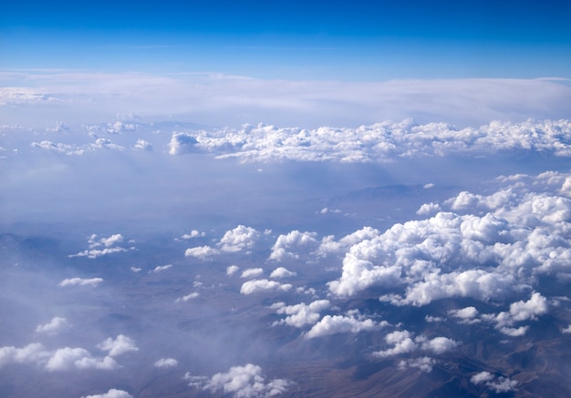 Blauwe hemelachtergrond met kleine wolken