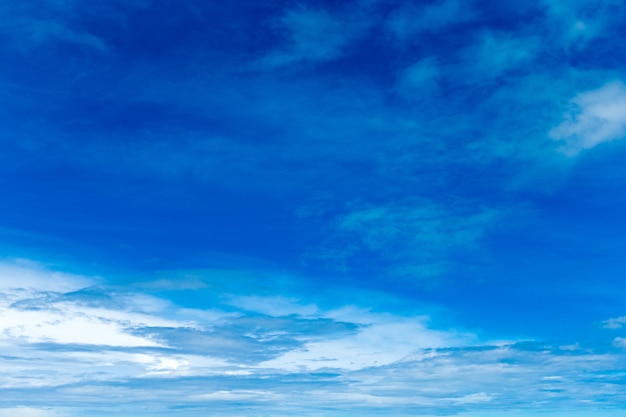 Blauwe hemelachtergrond met kleine wolken