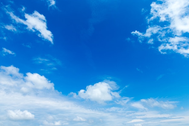Blauwe hemelachtergrond met kleine wolken