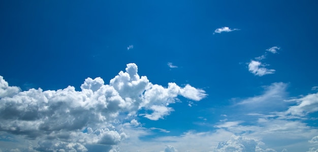 Blauwe hemelachtergrond met kleine wolken