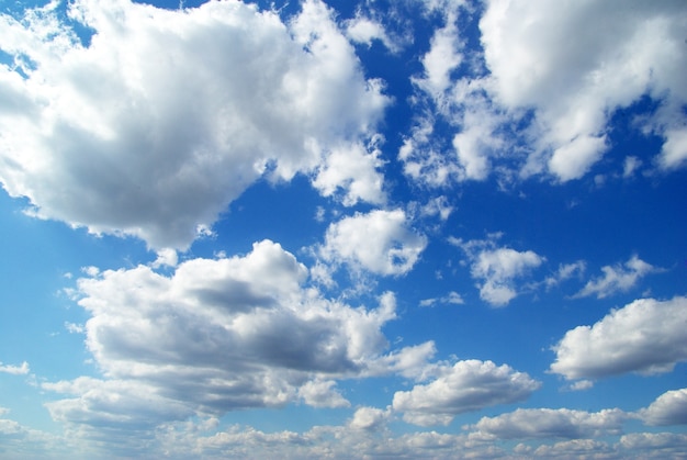 Blauwe hemelachtergrond met kleine wolken