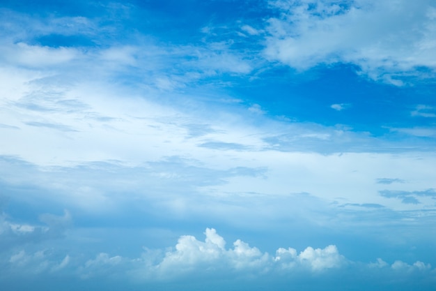 Blauwe hemelachtergrond met kleine wolken