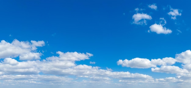 Blauwe hemelachtergrond met kleine wolken