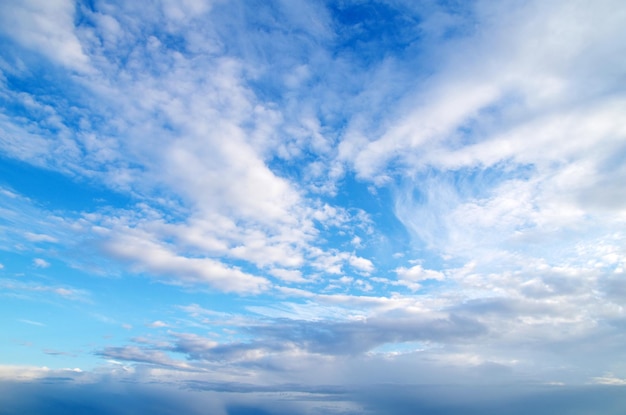 Blauwe hemelachtergrond met kleine wolken