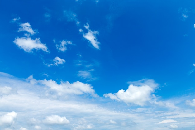 Blauwe hemelachtergrond met kleine wolken