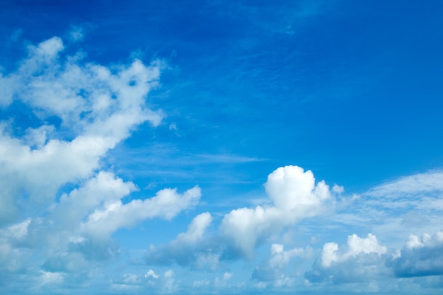 Blauwe hemelachtergrond met kleine wolken