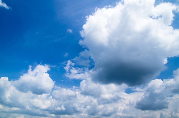 Blauwe hemelachtergrond met kleine wolken