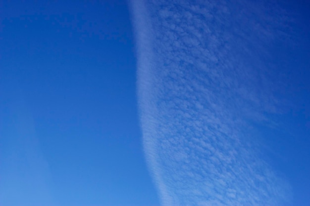 blauwe hemelachtergrond met lijn van wolken