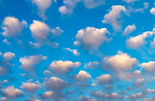 Blauwe hemelachtergrond met mooie pluizige witte wolken getint met kleur in avondlicht