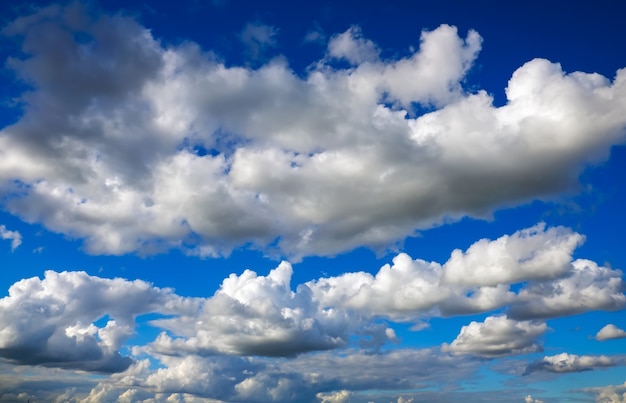 Blauwe hemelachtergrond met pluizige wolken