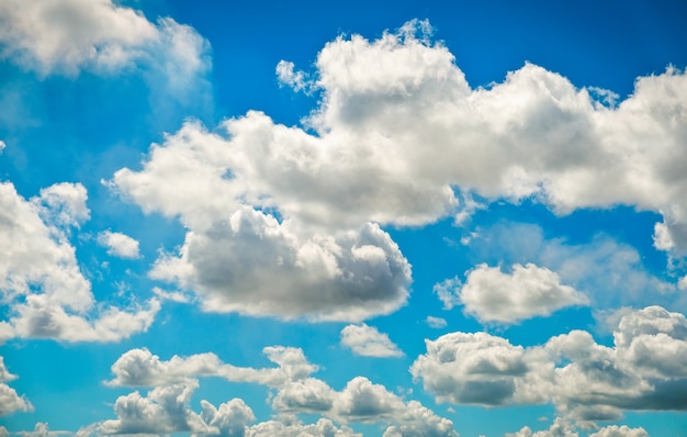 Blauwe hemelachtergrond met pluizige wolken