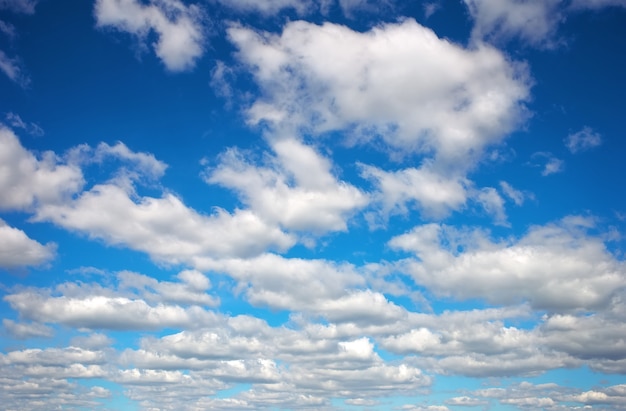 Blauwe hemelachtergrond met pluizige wolken