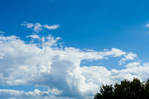 Blauwe hemelachtergrond met wit pluizig wolkenbeeld