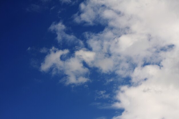 Blauwe hemelachtergrond met witte wolken