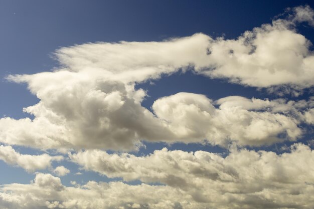 Blauwe hemelachtergrond met witte wolken