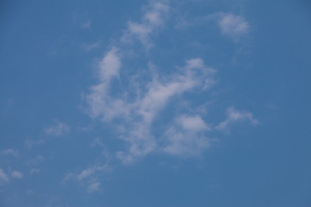 Blauwe hemelachtergrond met wolken.