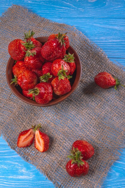 Blauwe houten tafel met een kom aardbeien