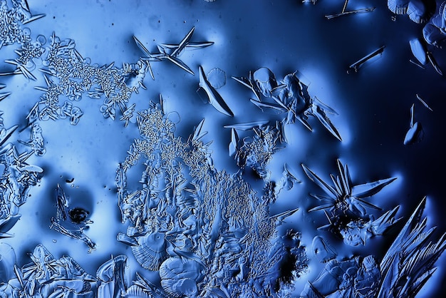 blauwe ijsglasachtergrond, abstracte textuur van het oppervlak van het ijs op het glas, bevroren seizoenswater