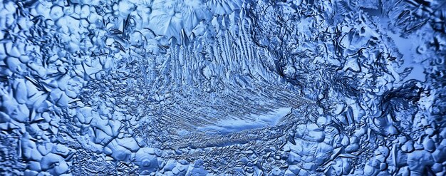 blauwe ijsglasachtergrond, abstracte textuur van het oppervlak van het ijs op het glas, bevroren seizoenswater