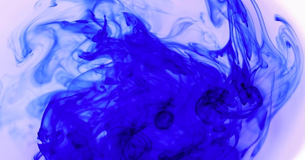 blauwe inkt in helder water in een witte schaal