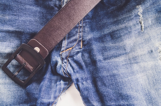 Blauwe jeans met oude bruine riem (man)