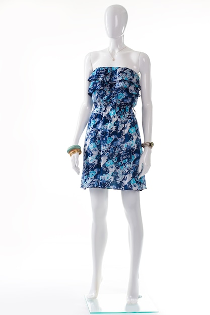 Blauwe jurk op witte etalagepop. Vrouwelijke etalagepop in vintage jurk. Strapless retro jurk en accessoires. Stijlvolle zomeroutfit voor jonge dames.
