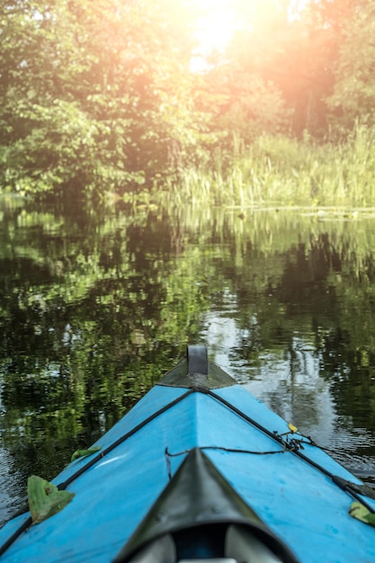 Blauwe kano op de rivier bij het bos