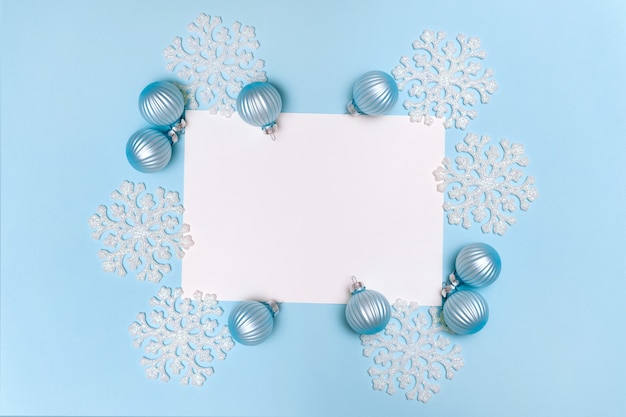 Blauwe kerstmisachtergrond met de ballen van de sneeuwvlokkendecoratie en lege spatie voor vlakke tekst legt exemplaarruimte