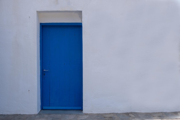 Blauwe kleur deur op een witte muur griekse eiland architectuur kopie ruimte